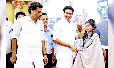 Minister Anbil Mahesh Poyyamozhi felicitates one of the students selected for the conference, on Saturday