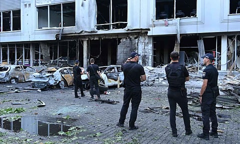 Police officers inspect damaged cars at a residential area following Russia's drone attack (AP Photo)