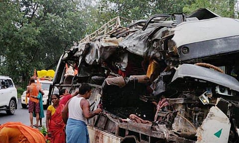 People stand near the wreckage of a vehicle after a collision took place between a bus with passengers on board and a truck, loaded with cooking gas cylinders, in Jharkhand’s Deoghar district, on July 29, 2025 (PTI)