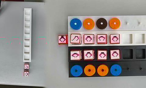 Atam incorporates physical components such as dice, dials, and holders