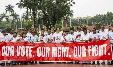 Congress MP Priyanka Gandhi Vadra and other INDIA bloc members seen wearing T-shirts featuring the name Minta Devi, a voter allegedly listed as 124 years old in the Election Commission's voter list, during their protest over the issues of 'poll fraud' and Special Intensive Revision of electoral rolls, at the Monsoon session of Parliament, in New Delhi, Tuesday, Aug. 12, 2025 (PTI)&nbsp;