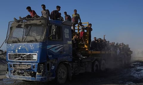 Palestinians ride on a truck used to transport humanitarian aid as it drives to Gaza City from the northern Gaza Strip (AP)