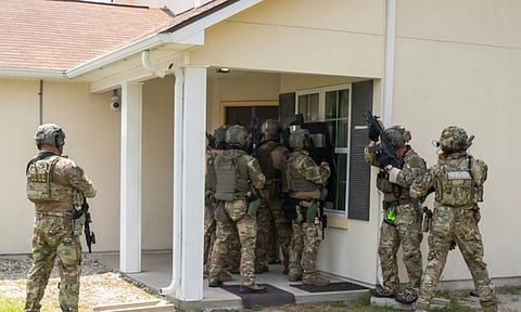 Immigration and Customs Enforcement (ICE) Special Response Team members demonstrate how the team enters a residence in the pursuit of a wanted subject at the Federal Law Enforcement Training Centers (FLETC) in Brunswick (AP)