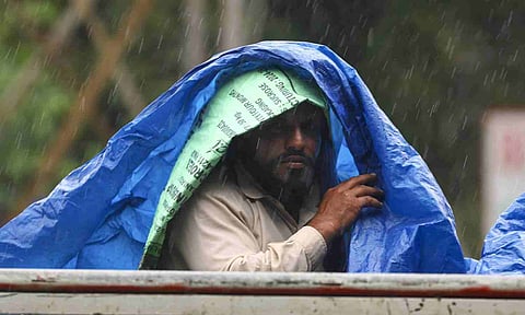 A man covers himself with a plastic sheet amid rainfall, in Jammu, Sunday, Aug. 31, 2025 (PTI)&nbsp;