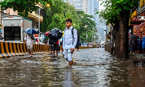 People wade through a flooded road (PTI)