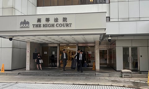 People walk out of the Hong Kong High Court in Admiralty, Hong Kong (AP)