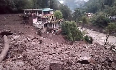 Houses lay damaged amidst mud and debris after a landslide triggered by heavy rains at Nandanagar in Chamoli district (PTI)