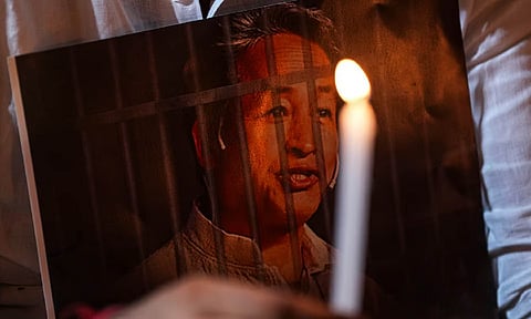 An agitator holds a poster and a candle during a protest condemning the arrest of climate activist Sonam Wangchuk, at Jantar Mantar, in New Delhi (PTI)