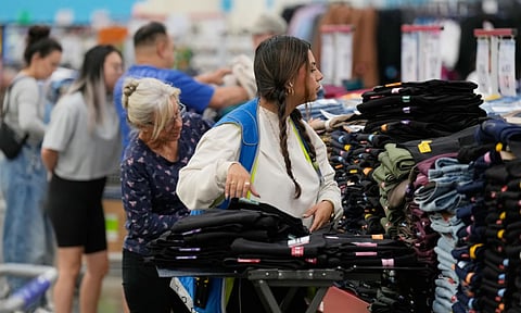 A worker stocks a display of clothing at Sam's Club (Photo: AP)