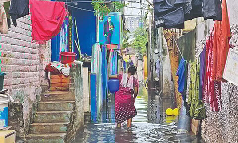 A resident of Pattalam wades through waterlogged street