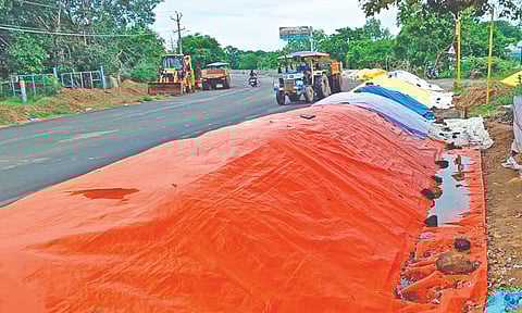Paddy stocks along the road in front of a DPC in Thanjavur