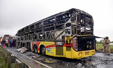 A Hyderabad-bound private bus after it caught fire following a collision with a two-wheeler, near Chinnatekur in Kurnool district (PTI)