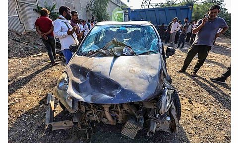 People look at the wrecked remains of a vehicle after a speeding dumper truck rammed into several other vehicles in Jaipur's Harmada area, on Nov 3, 2025. At least 12 people were killed and as many injured in the incident (PTI)&nbsp;