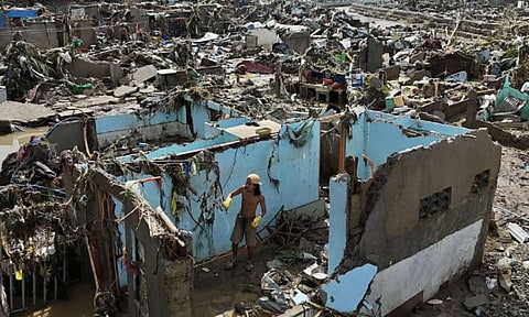 A resident returns to what remains of their homes after Typhoon Kalmaegi caused devastation in communities along the Mananga River in Talisay City, Cebu province, central Philippines (AP)