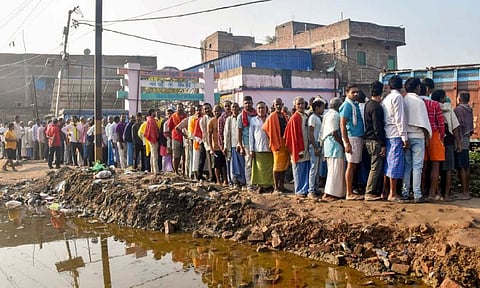 Voters wait in a queue to cast votes at a polling station during the first phase of the Bihar Assembly elections, in Patna, on Thursday. (PTI)