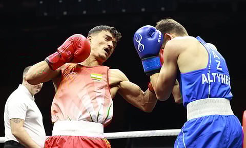Pawan Bartwal lands a hook on Altynbek Nursultan during his match