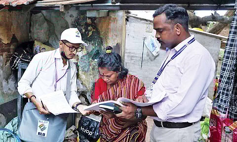 Booth-level officer (BLO) distributing the SIR forms to the public.&nbsp;