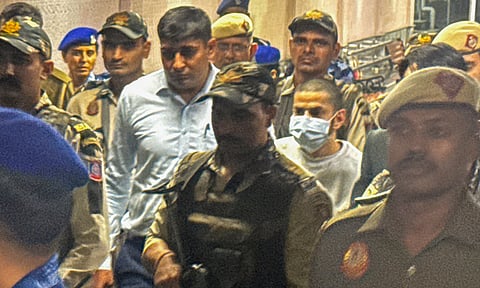 Gangster Anmol Bishnoi, in mask, while being produced in the Patiala House Court, in New Delhi. The court on Wednesday sent Bishnoi, the brother and close aide of gangster Lawrence Bishnoi, to 11 days of NIA custody. The federal agency had arrested him upon his deportation from the US (PTI)