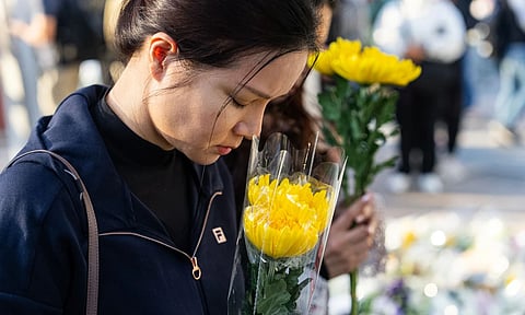 People pay respects to the dead (Photo: AP)