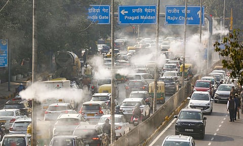 Commuters make their way as water droplets are sprayed through the new mist spray system, installed to curb air pollution, in New Delhi, Thursday, Dec. 4, 2025. (PTI)