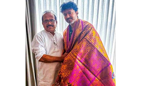 Nanjil Sampath presenting a 'ponnadai' to TVK chief actor Vijay at his Panaiyur office on Friday&nbsp;