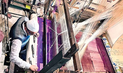 A handloom weaver in Varanasi crafting intricate designs on a traditional silk saree&nbsp;