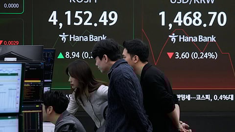 Currency traders watch monitors near a screen showing the Korea Composite Stock Price Index (KOSPI) and the foreign exchange rate between U.S. dollar and South Korean won, right, at the foreign exchange dealing room of the Hana Bank headquarters in Seoul, South Korea. 
