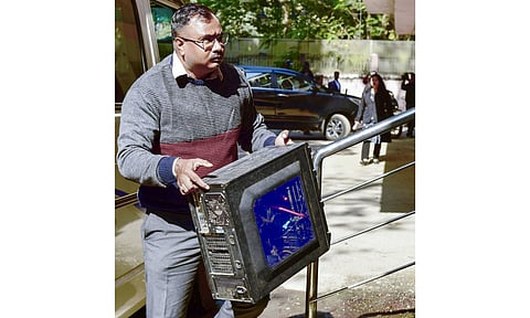 A Special Investigation Team (SIT) officer carrying a CPU arrives at a court in connection with the Zubeen Garg death case, in Guwahati. The SIT on Friday submitted the chargesheet in the case. (Photo: PTI)