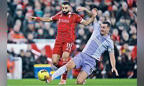 Brighton’s Lewis Dunk tackles Liverpool’s Mohamed Salah