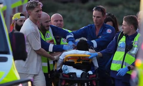 Emergency workers transport a person on a stretcher after a reported shooting at Bondi Beach (AP)