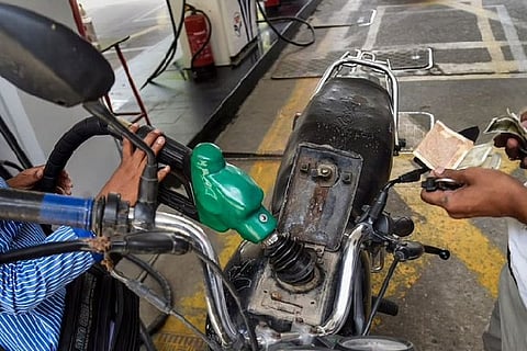 A pump attendant fills petrol in a bike at a fuel station in New Delhi