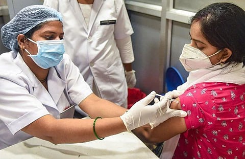 A health worker taking giving a Covid jab