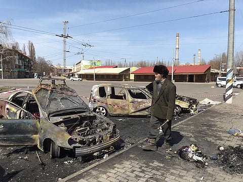 A man walks past burned cars at the site of a missile strike, at a rail station, amid Russia's invasion of Ukraine, in Kramatorsk.