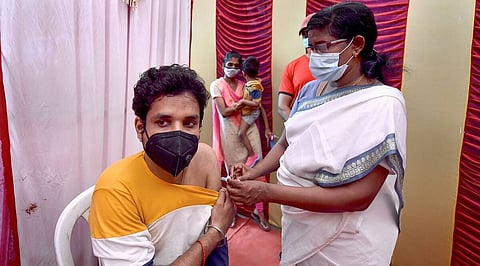A health worker gives a Covid jab to a person