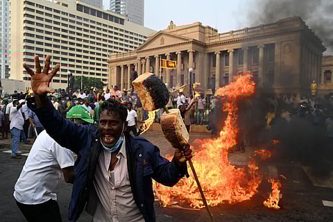 An activist shouts and holds up burning bread as he protests rising living costs at the entrance of the president?s office in Colombo, Sri Lanka