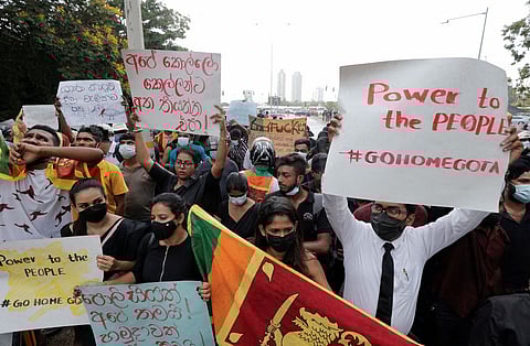 People hold placards as they demand Sri Lanka's President Gotabaya Rajapaksa to resign after his government lost its majority in the parliament, amid the country's economic crisis