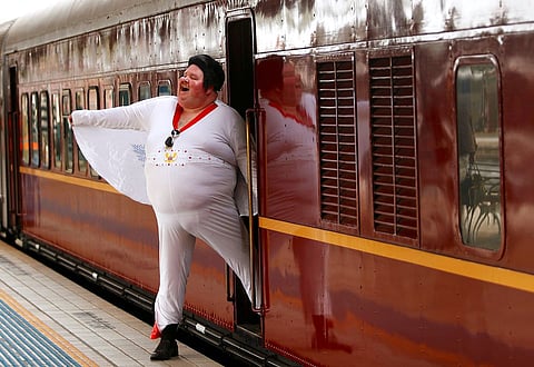 Elvis Presley impersonator Sean Wright poses next to the Elvis Express train at Sydney's Central station before it departs for the 26th annual Elvis Festival