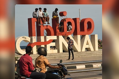 Youngsters sitting on the top of a vandalised 'Namma Chennai' selfie point