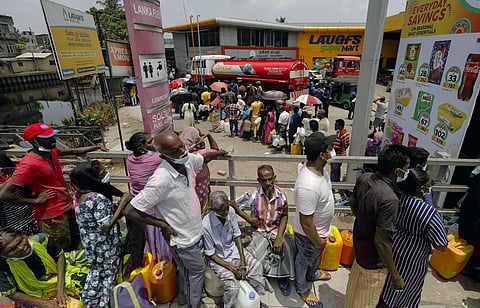 People stand in a long queue to buy kerosene oil for kerosene cookers amid a shortage of domestic gas due to country's economic crisis