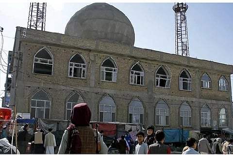 This frame grab image from video, shows a Taliban fighter standing guard outside the site of a bomb explosion inside a mosque, in Mazar-e-Sharif province, Afghanistan