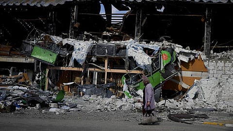 A woman walks in front of a damage building ruined by attacks in Irpin, outskirts Kyiv, Ukraine