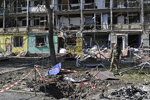 A Ukrainian serviceman walks next to an apartment building destroyed by night shelling in Kramatorsk