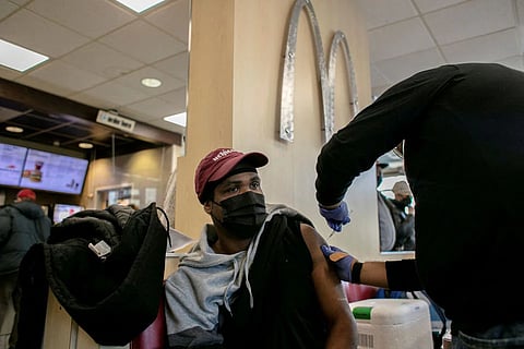 A man receives a booster shot for Covid at a McDonald's, as the Omicron coronavirus variant spreads through the country