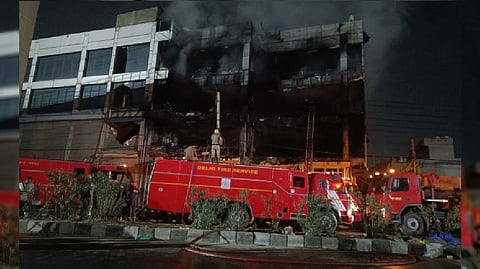Firefighters try to douse a fire which broke out in a building at Mundka, in West Delhi