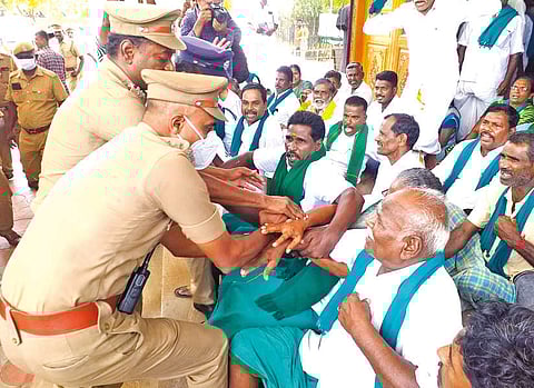 Police personnel forcibly removing agitating farmers from Tiruchy Collectorate on Friday