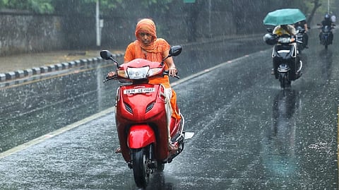 A women riding her bike without a raincoat
