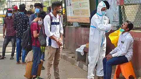 A health worker collects swab samples of passengers for the Covid test in Bengaluru