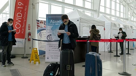 Travellers look at Covid-19 results after being tested inside JFK International airport in New York