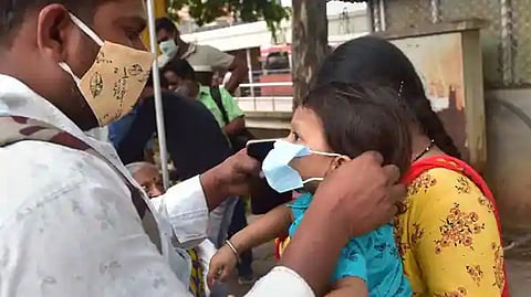 A man helps his son to wear mask at Covid test centre at KSRTC bus stand in Bengaluru.