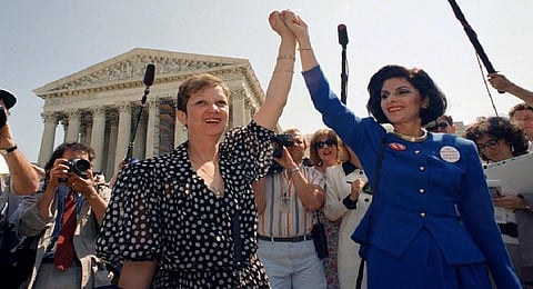 Norma McCorvey, Jane Roe in the 1973 court case, left, and her attorney Gloria Allred hold hands as they leave the Supreme Court building in Washington